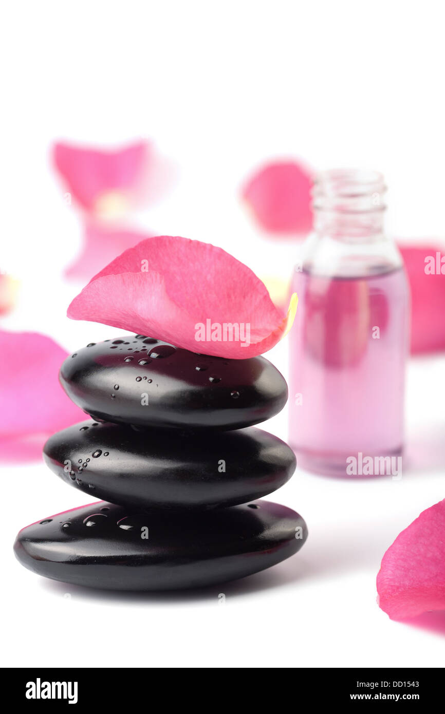 Spa pietre, olio essenziale e petali di rosa isolato Foto Stock