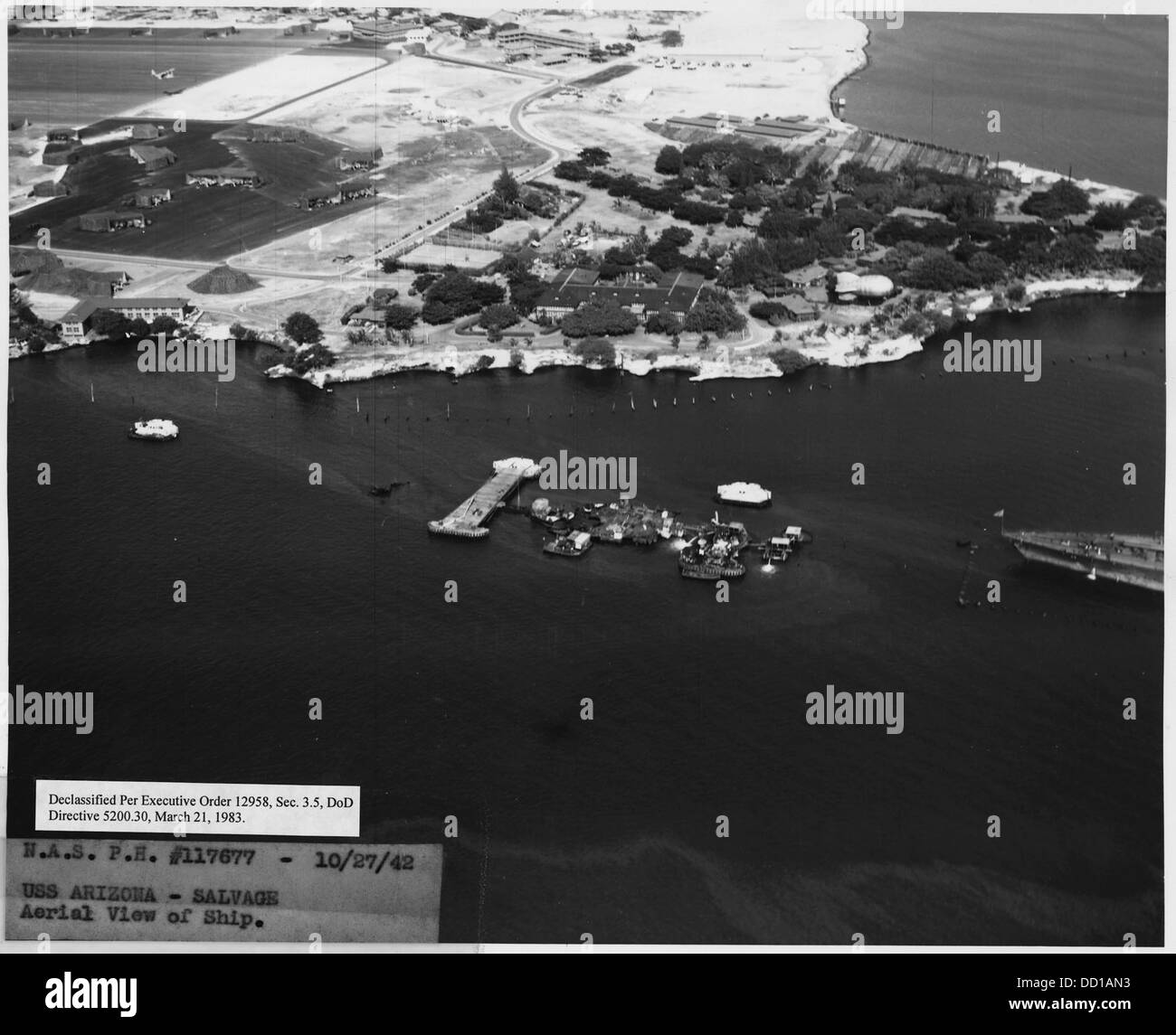 Questa vista aerea cattura la USS Arizona dopo l'attacco a Pearl Harbor, mostrando i danni subiti dalla nave. Anche le operazioni di salvataggio successive all'attacco sono documentate in questa fotografia. Foto Stock