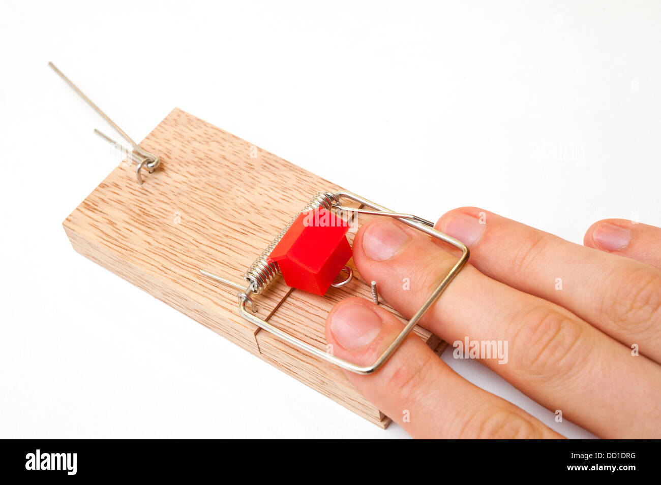 Una mano e casa catturato in un mousetrap Foto Stock