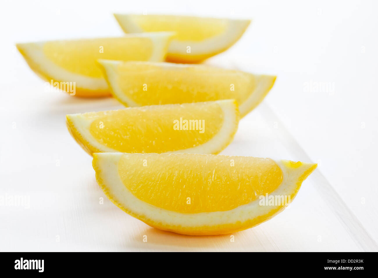Spicchi di limone o fette su uno sfondo bianco con le ombre morbide. Foto Stock