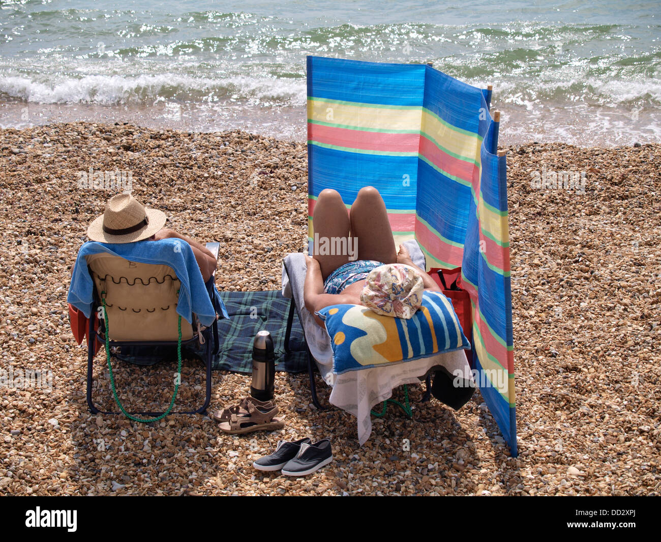 Coppia matura godendo una giornata in spiaggia, Milford on Sea, Hampshire, Regno Unito 2013 Foto Stock