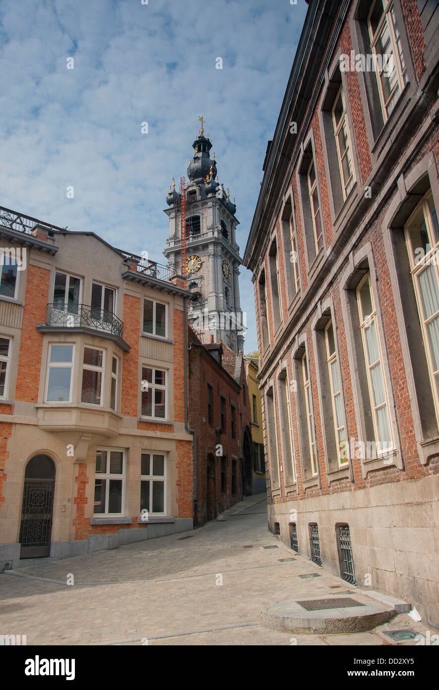 Tradizionale Street nel quartiere vecchio di mons in belgiu con il campanile barocco in background Foto Stock