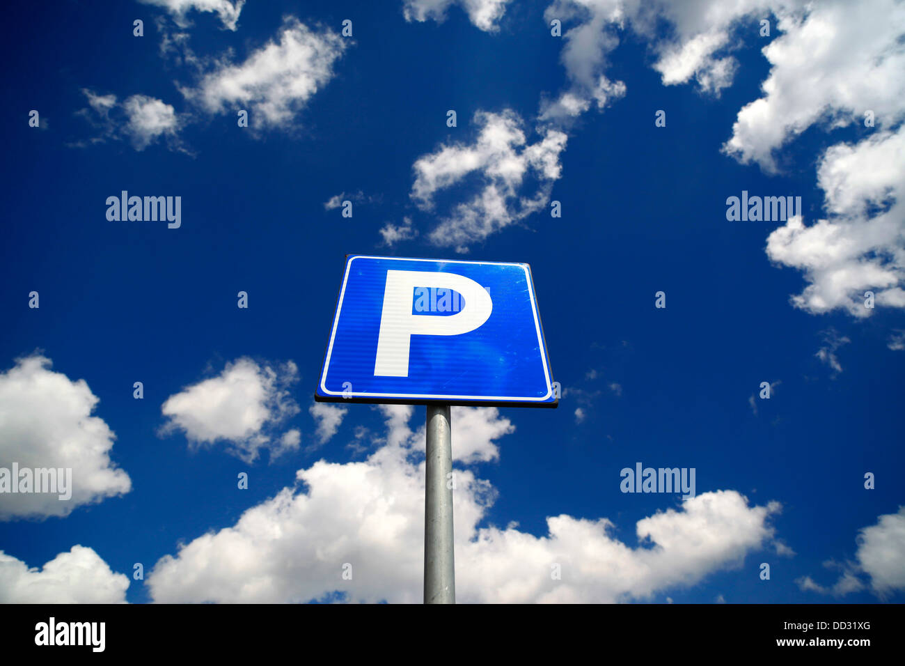 Parcheggio segno contro il cielo blu e nuvole bianche. Foto Stock