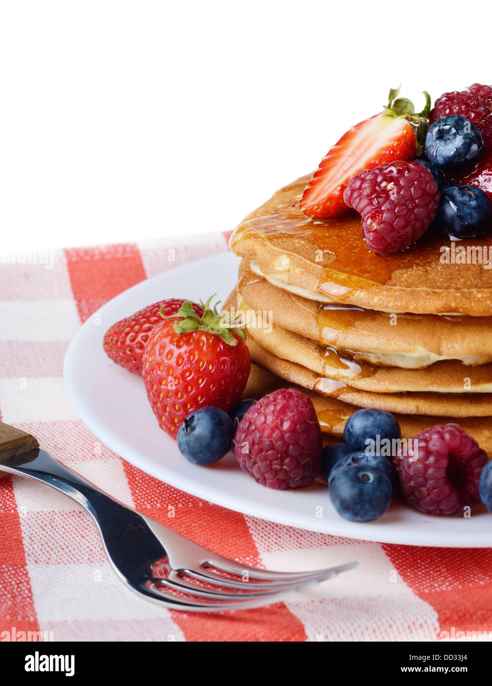 Piastra di colore bianco pieno di pancake con Fragole Lamponi Mirtilli e  miele su bianco Foto stock - Alamy