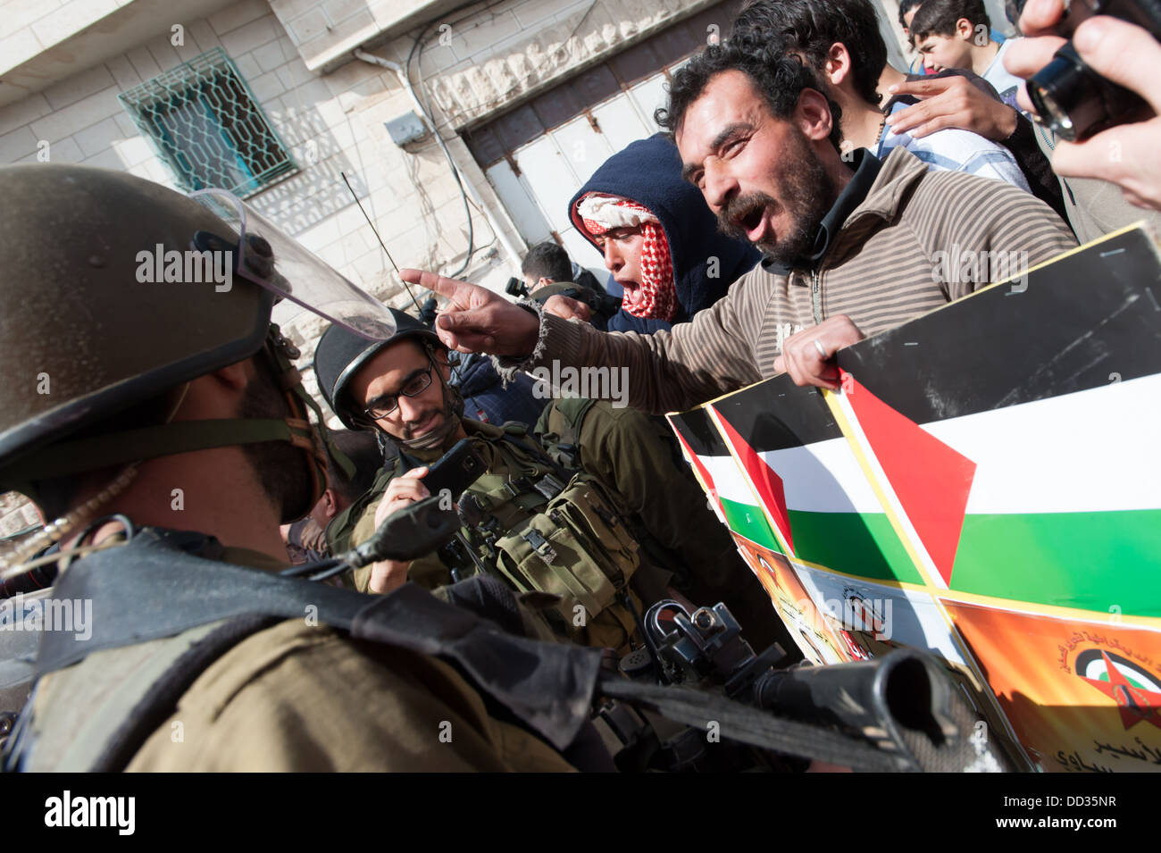 Attivisti palestinesi confrontarsi con soldati israeliani durante una dimostrazione contro l'occupazione. Foto Stock