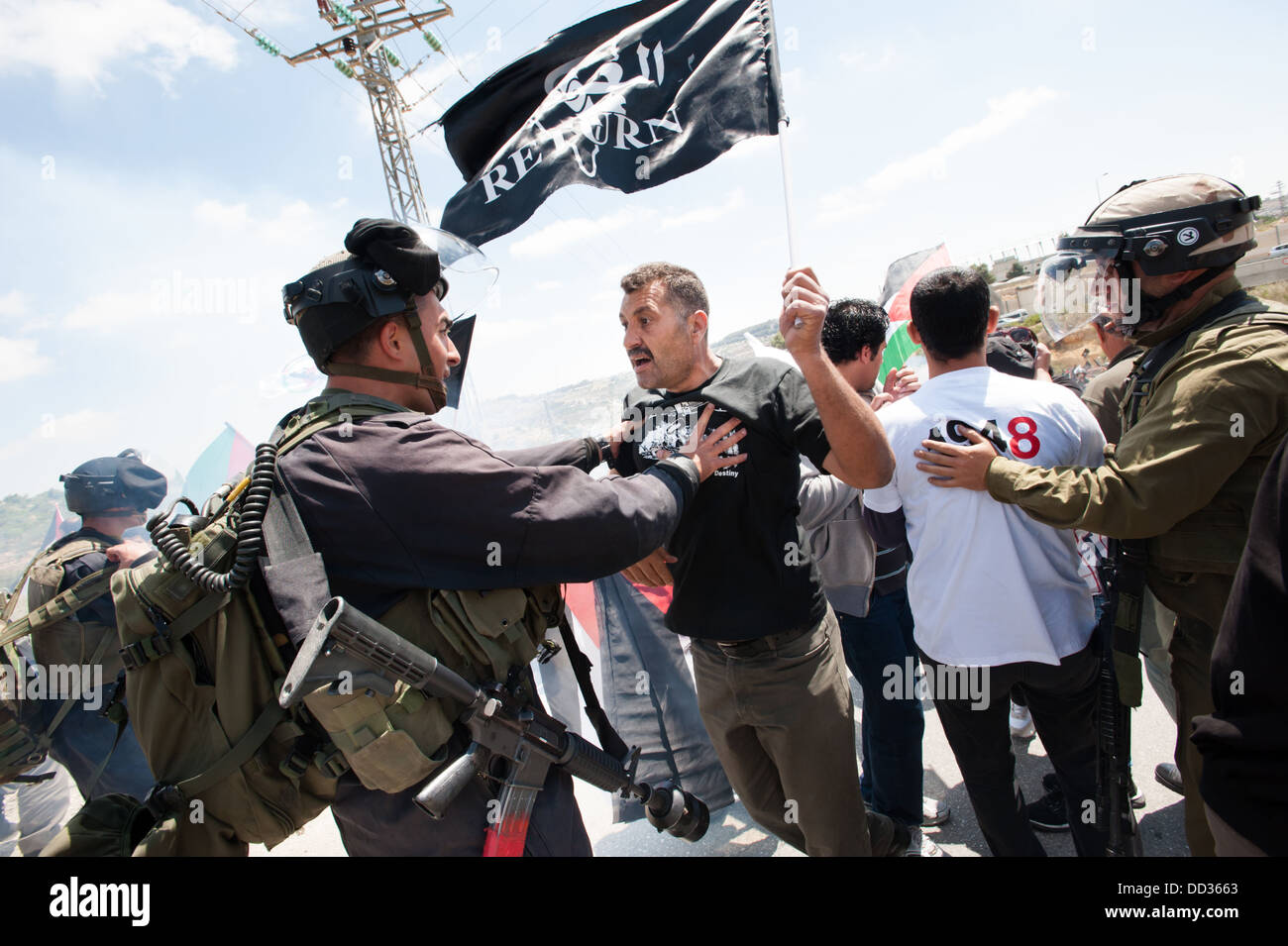 Attivisti palestinesi confrontarsi con soldati israeliani bloccando la loro marcia verso la linea verde nei pressi del villaggio di Husan. Foto Stock