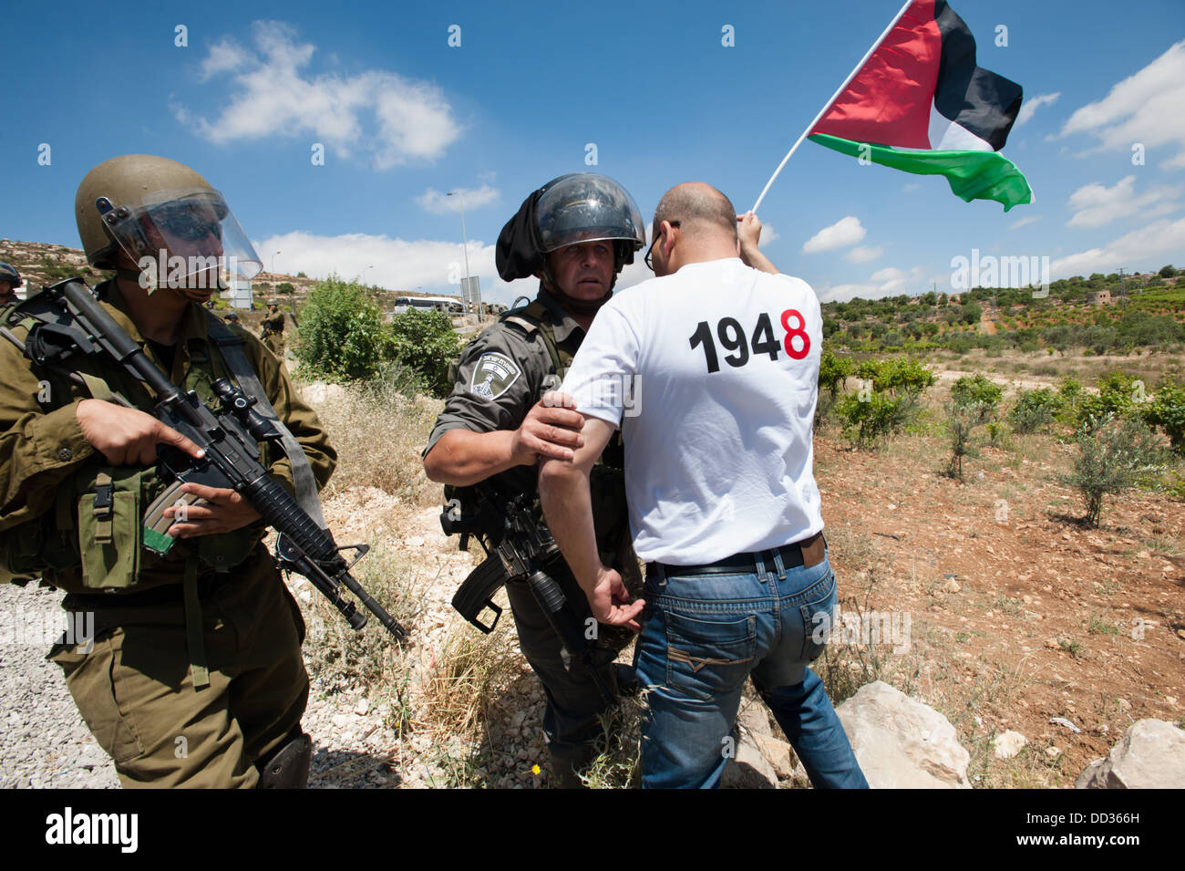 Attivisti palestinesi confrontarsi con soldati israeliani bloccando la loro marcia verso la linea verde nei pressi del villaggio di Husan. Foto Stock
