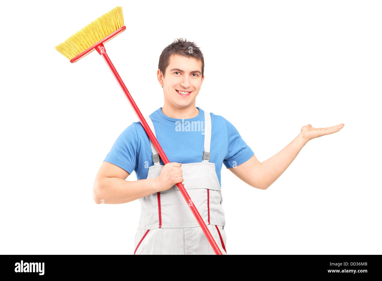 Il detergente in un uniforme con una scopa puntando con il suo braccio Foto Stock