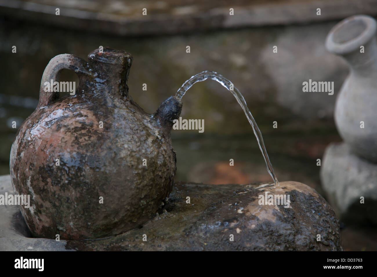 Brocca di argilla con acqua uscente da esso Foto Stock