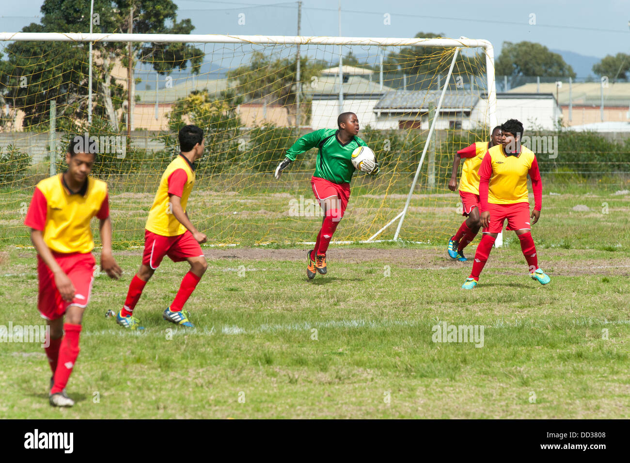 U15B portiere di calcio in azione giocando una partita di Cape Town, Sud Africa Foto Stock
