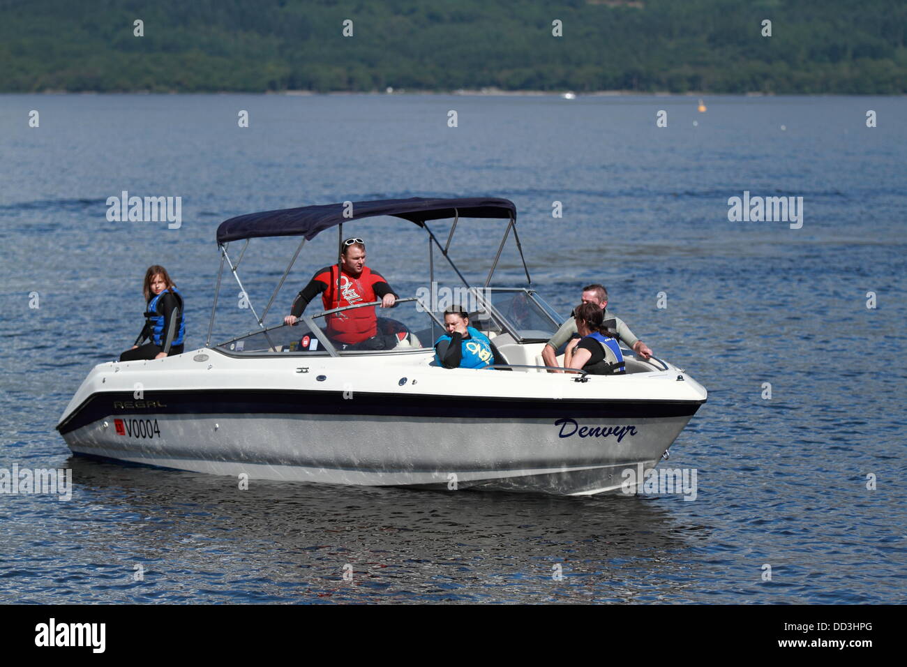 Un piccolo motoscafo si prepara alla riva presso la spiaggia di Luss, Loch Lomond Scozia, Regno Unito Foto Stock