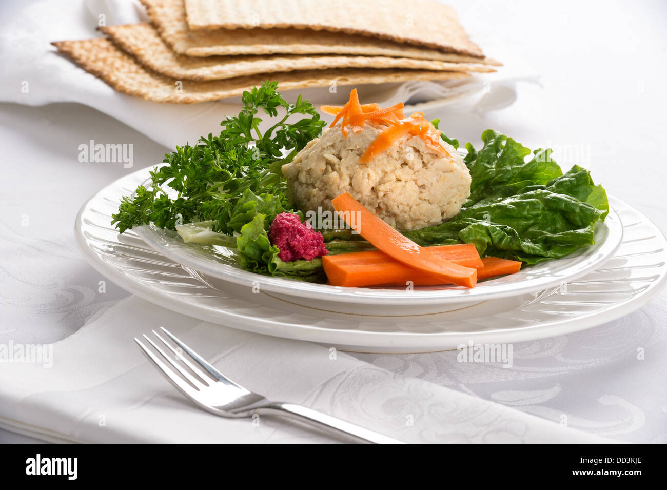 Tradizionale pasqua ebraica cibo pesce gefilte con carote, prezzemolo, rafano, e lattuga su tovaglie bianche tovaglie Foto Stock