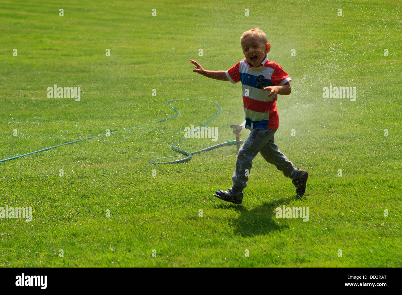 Ragazzo giocando con l'irroratore. Foto Stock