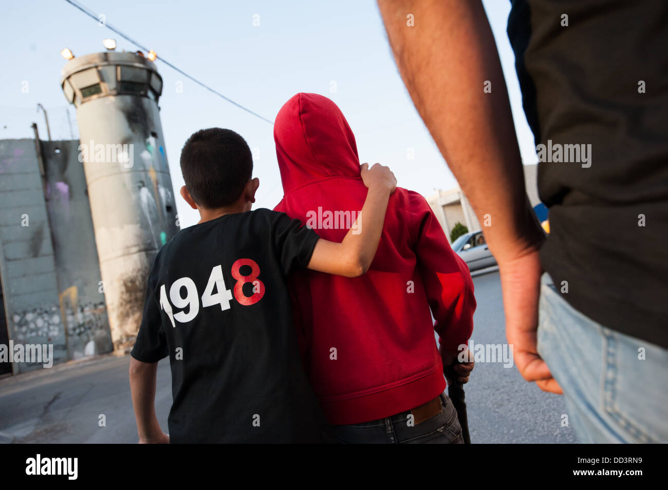 Palestinesi passano la separazione israeliano parete mentre marciando per le strade di Betlemme per commemorare la Nakba. Foto Stock