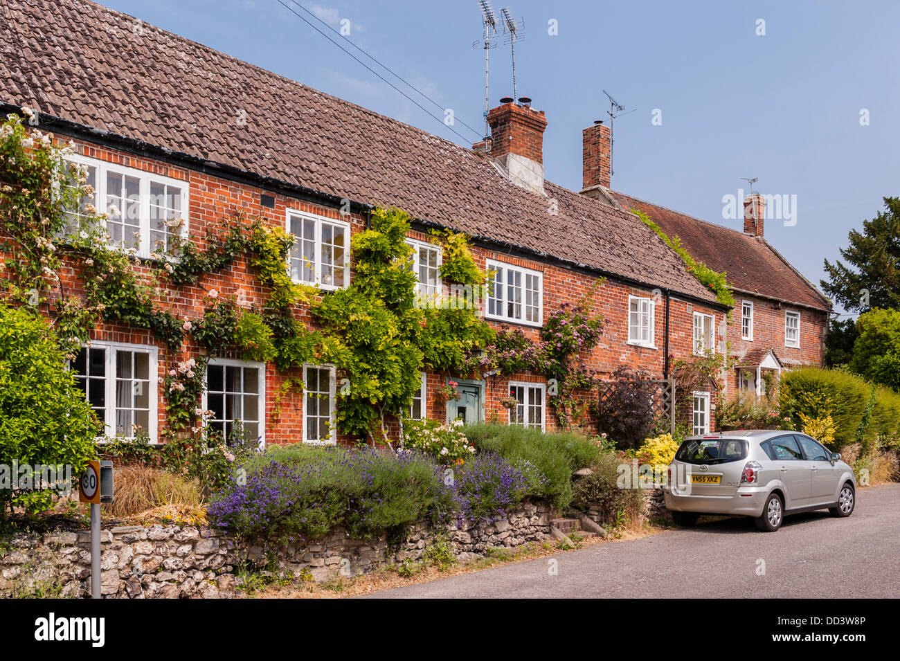 Una fila di terrazze coltivate a mattoni rossi cottages in Steeple Langford , Wiltshire , Inghilterra , Inghilterra , Regno Unito Foto Stock