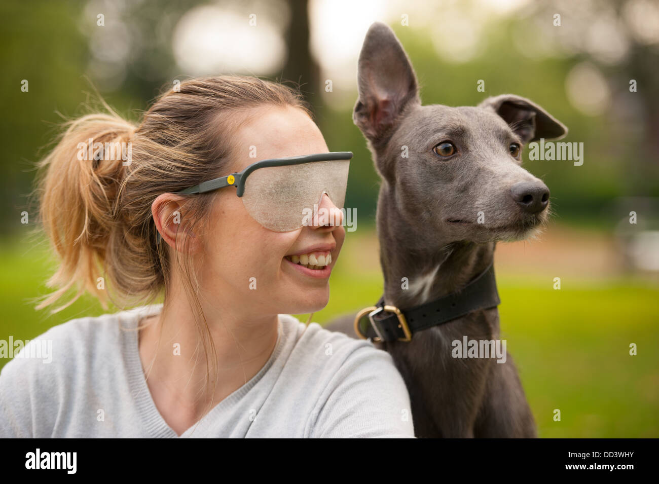 Giovane donna che indossa una disabilità visiva occhiali di simulazione con il cane Foto Stock