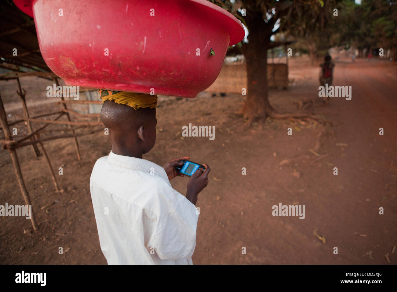 Ragazzo multi-tasking in Port Loko, Sierra Leone. Foto Stock