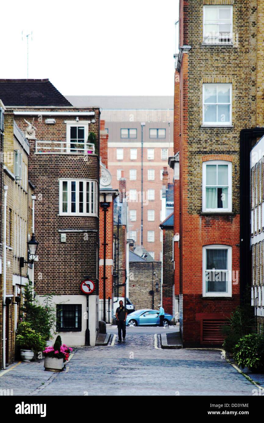 Persona che cammina verso il basso uno dei londinesi nelle strade laterali a Mayfair Foto Stock