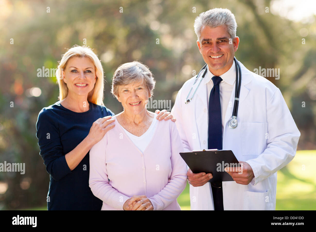Medico in piedi con il senior paziente e sua figlia all'aperto Foto Stock