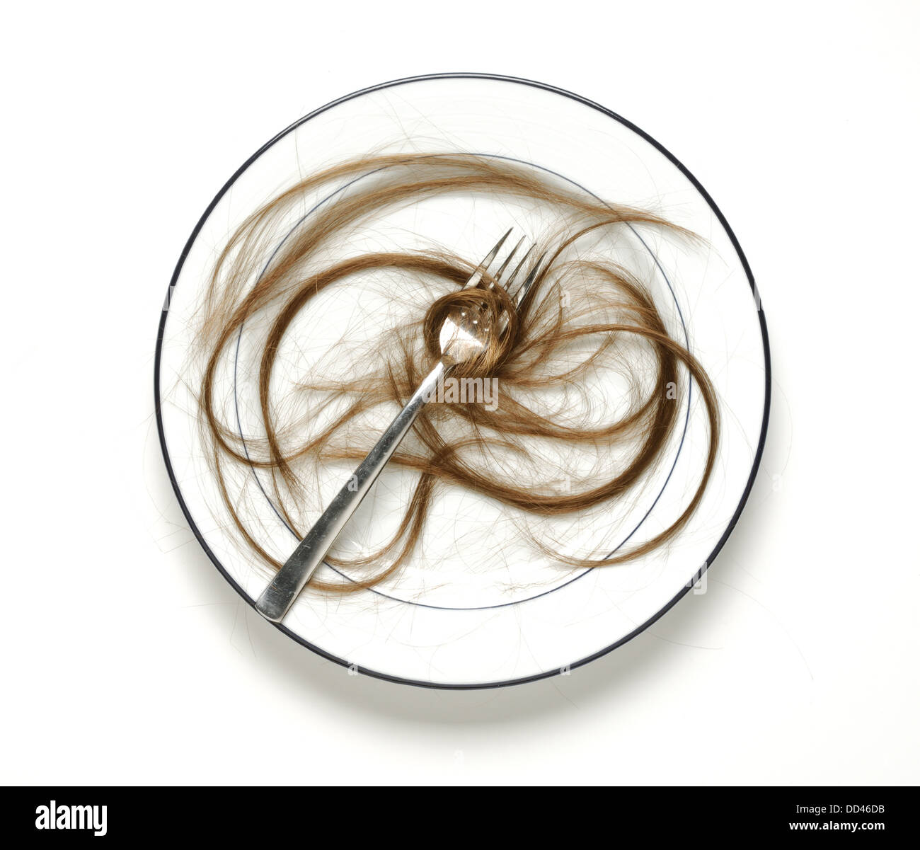 Una piastra da pranzo con una forchetta e tante ciocche di capelli umani Foto Stock