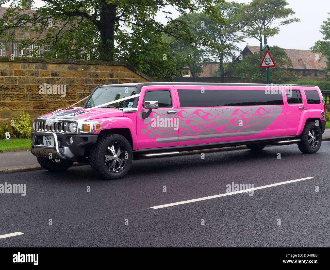 Un rosa luminoso HUMMER limousine allungata con nastri bianchi decorazioni per matrimoni Foto Stock