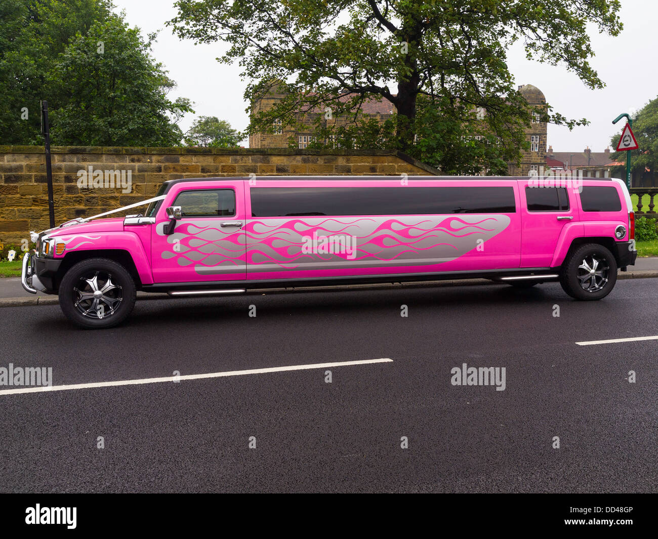 Un rosa luminoso HUMMER limousine allungata con nastri bianchi decorazioni per matrimoni Foto Stock