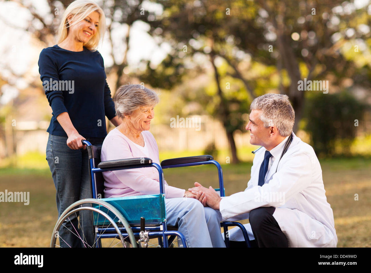 Medico di sesso maschile di parlare con handicap donna senior presso la casa di riposo Foto Stock