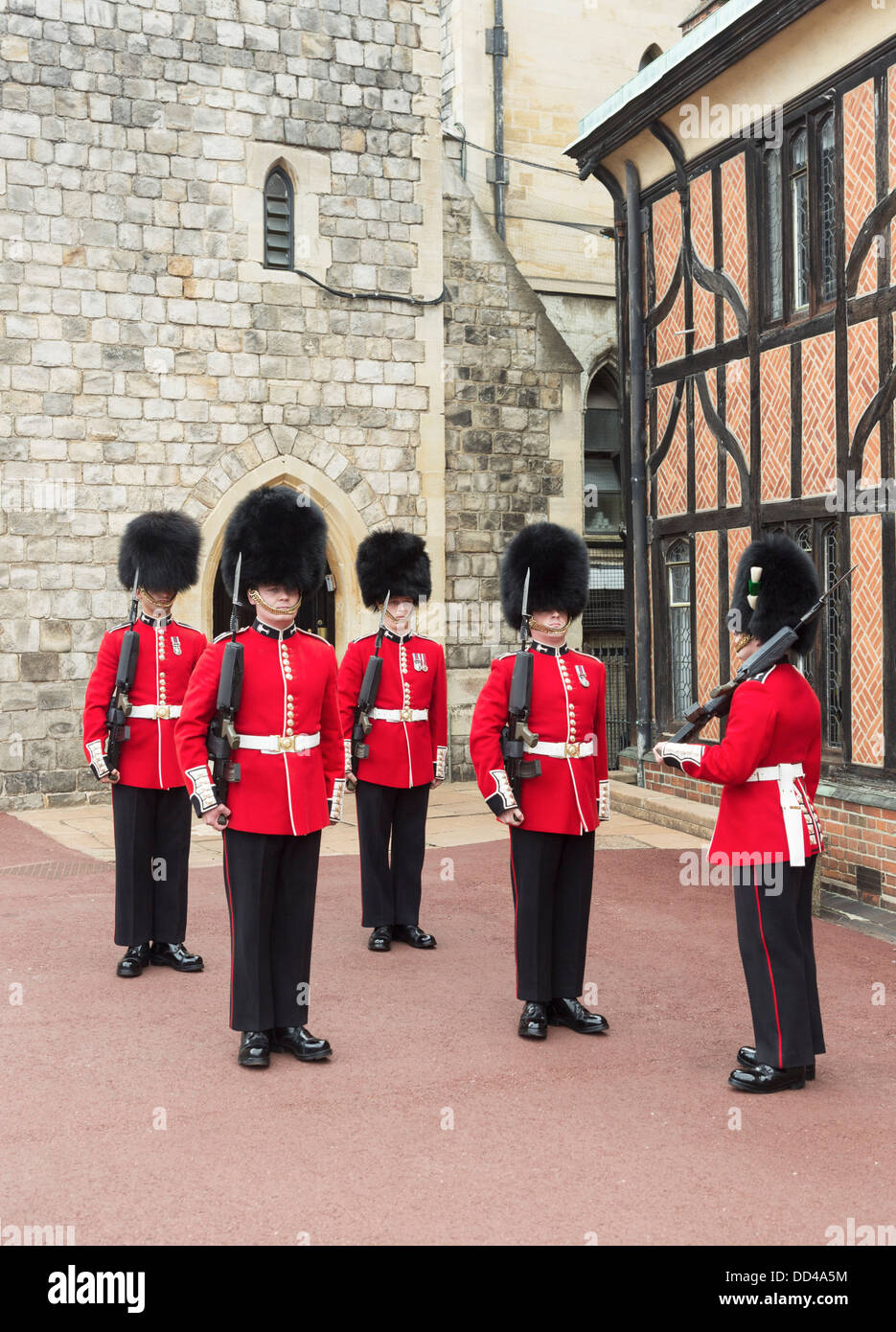 I soldati in regina della guardia al Castello di Windsor in Inghilterra, con il rosso uniforme, pistole e nero tradizionale berretto in pelliccia di orso o busby Foto Stock