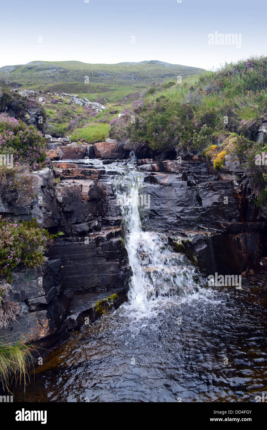 Una piccola cascata che scorre verso il basso in Loch Home dalla Scottish montagna montagne scozzesi Beinn Enaiglair (a Corbett ). Foto Stock