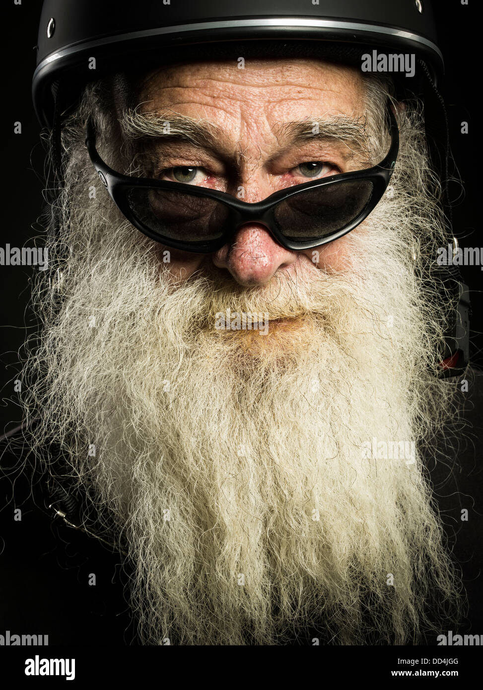 Vecchio biker con la barba bianca e casco Foto Stock