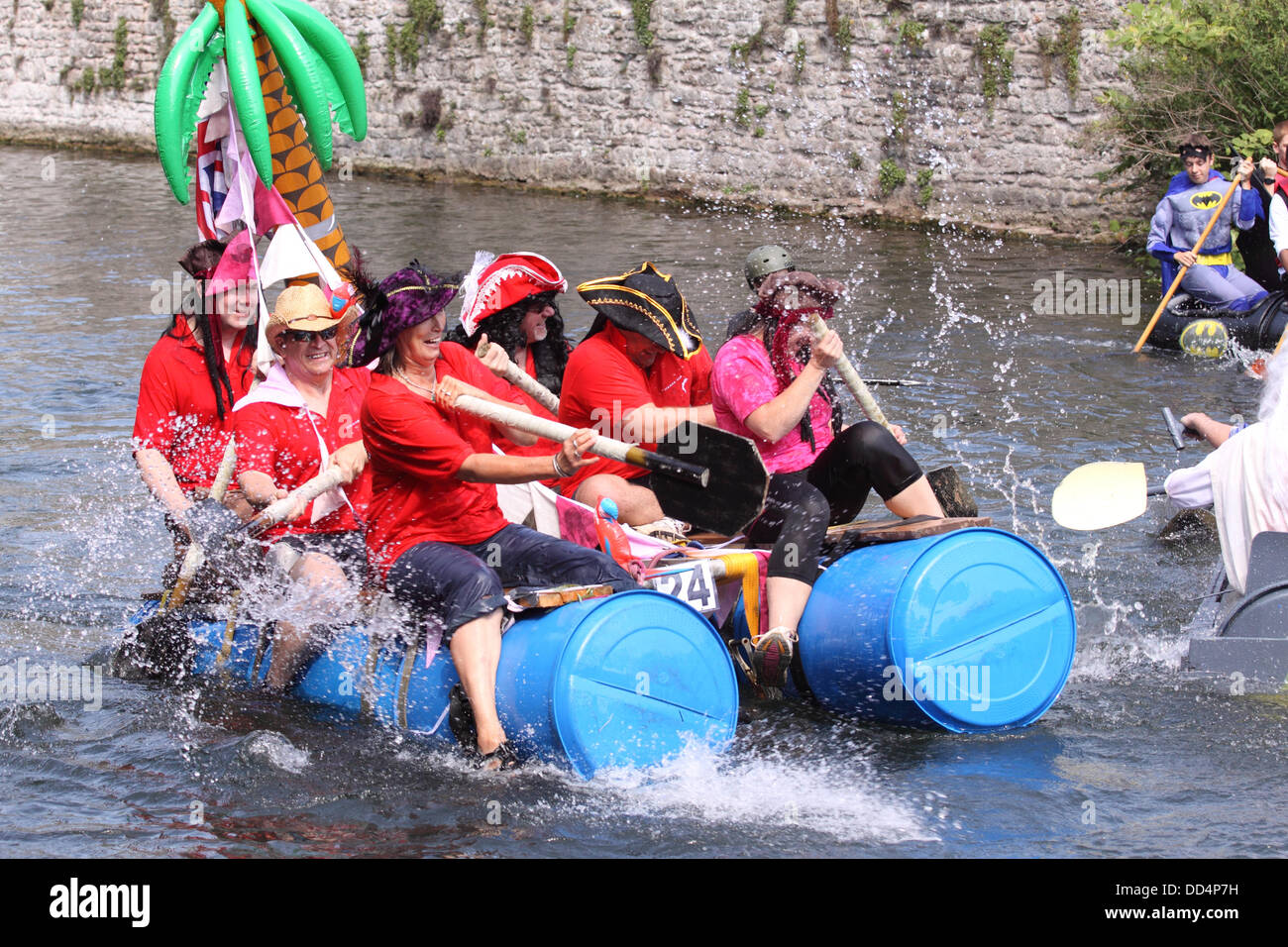 Pozzetti, Somerset, Regno Unito a Ferragosto Moat Boat Race a Wells Somerset REGNO UNITO - concorrenti in casa paddle zattere lungo il Palazzo dei Vescovi fossato Foto Stock