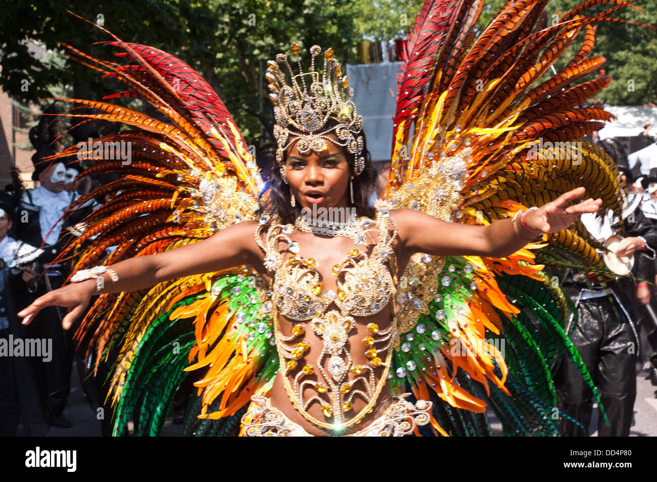 Londra, Regno Unito. 26 Ago, 2013. una donna vestita in un colorato costume di piume danze alla fotocamera durante la parata annuale presso il carnevale di Notting Hill. Credito: Piero Cruciatti/Alamy Live News Foto Stock