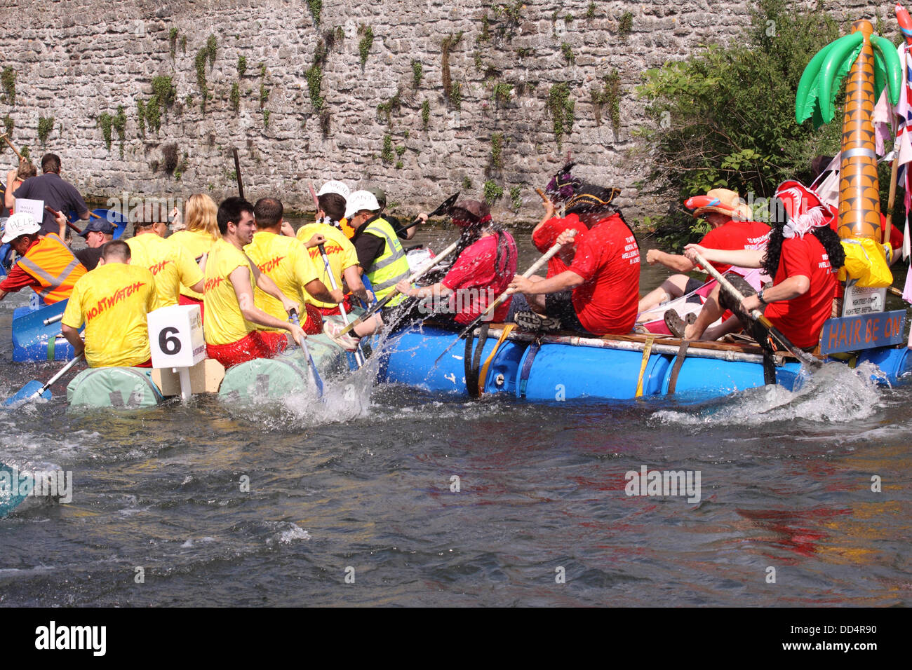 Pozzetti, Somerset, Regno Unito. A ferragosto Moat Boat Race a Wells Somerset REGNO UNITO - concorrenti in casa paddle zattere lungo il Palazzo dei Vescovi fossato Foto Stock