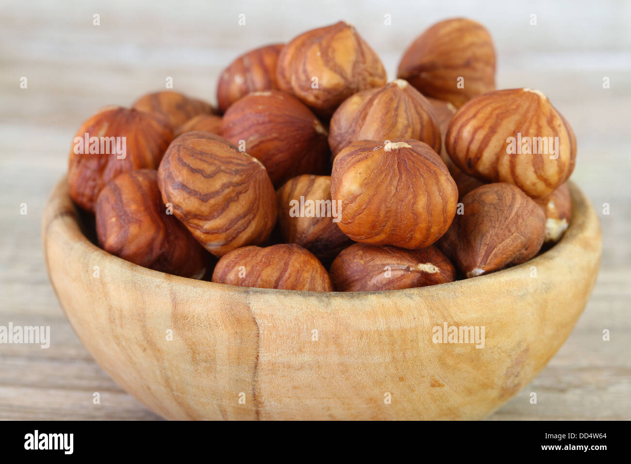 Le nocciole in ciotola di legno, close up Foto Stock