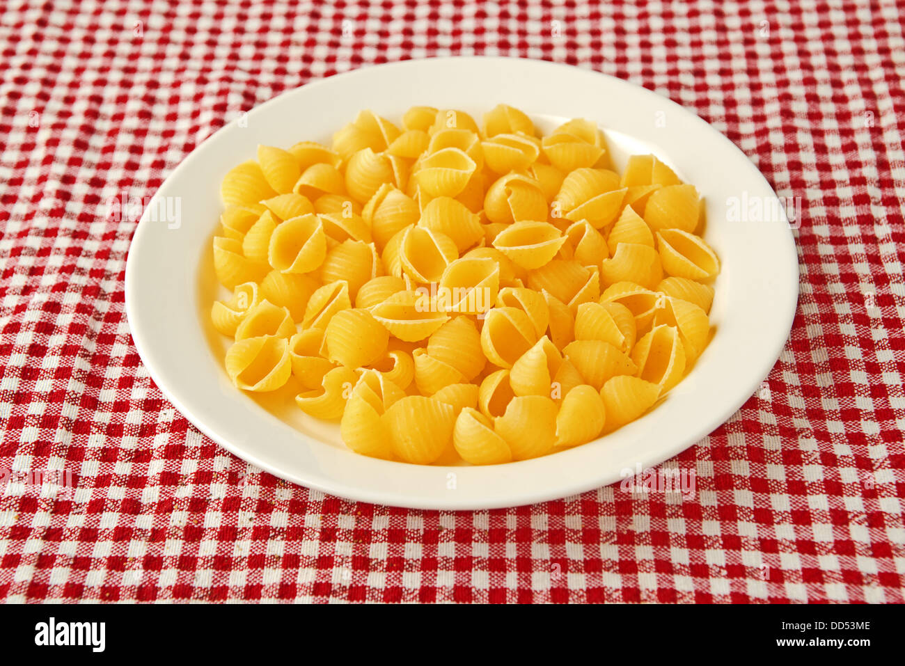 La pasta grezza su piastra bianca sul tavolo da cucina Foto Stock