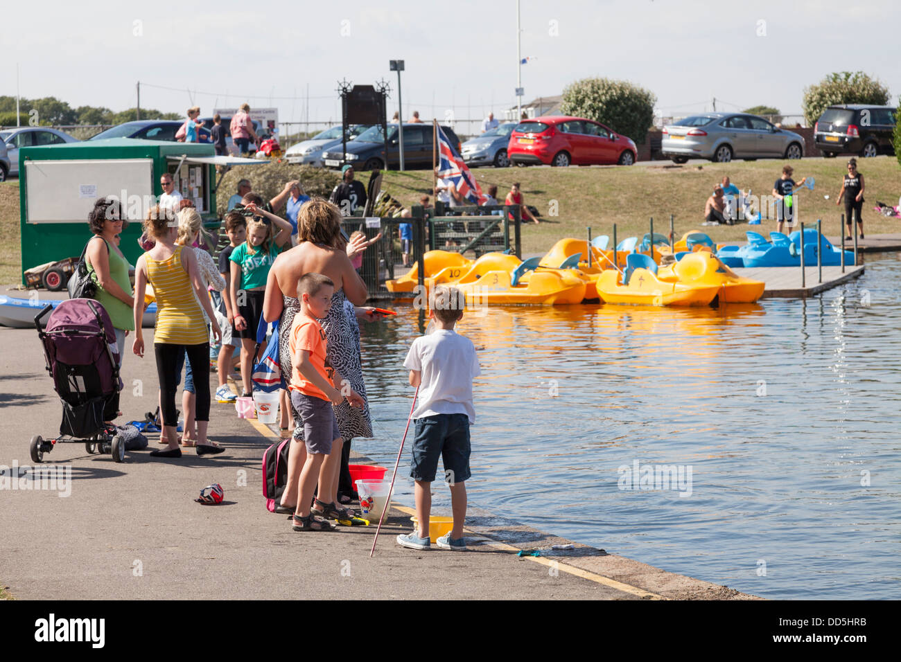 Famiglie avendo divertimento all'Oyster Pond in barca il lago di Littlehampton Foto Stock