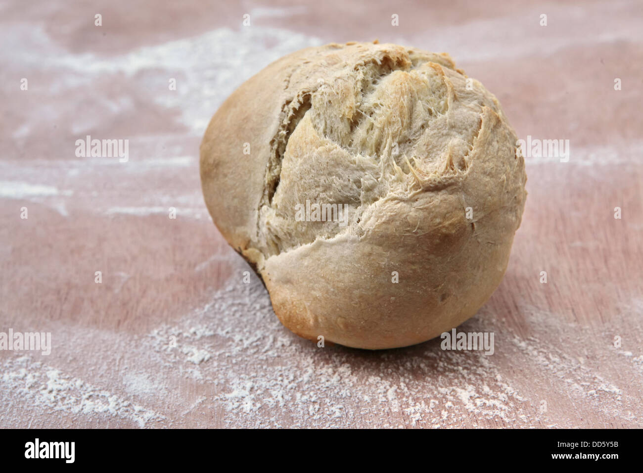 Pane appena sfornato rotolo su una coperta di farina di bordo in un forno Foto Stock