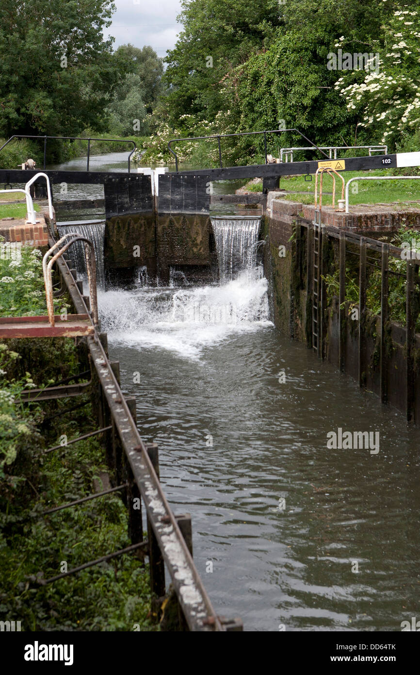 Acqua versando in un blocco sul Kennet and Avon Canal, spruzzi d'acqua sui davanzali. Foto Stock