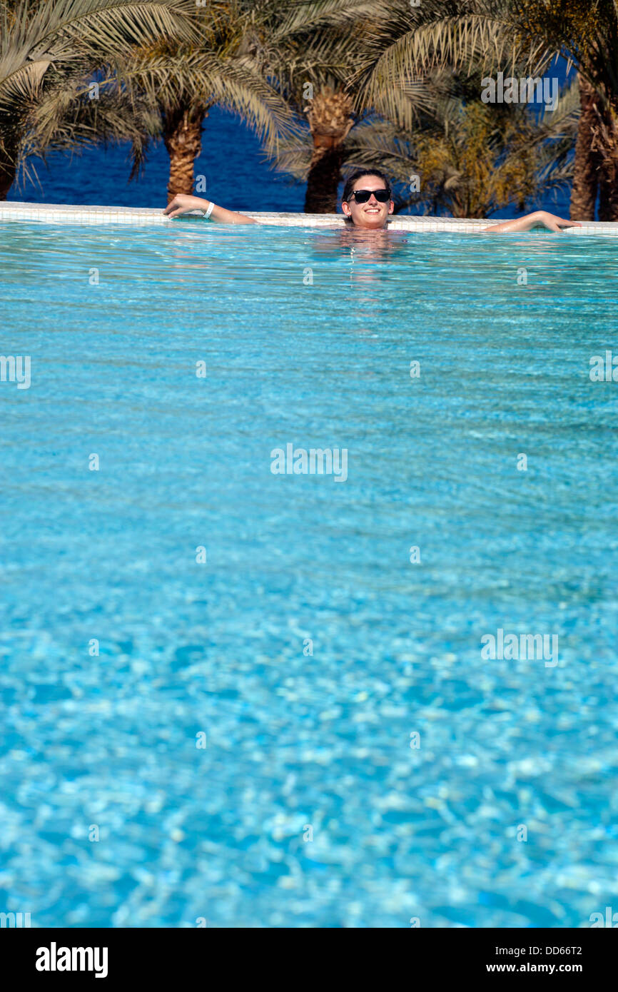 La donna in una piscina infinity/messa a fuoco poco profonda Foto Stock