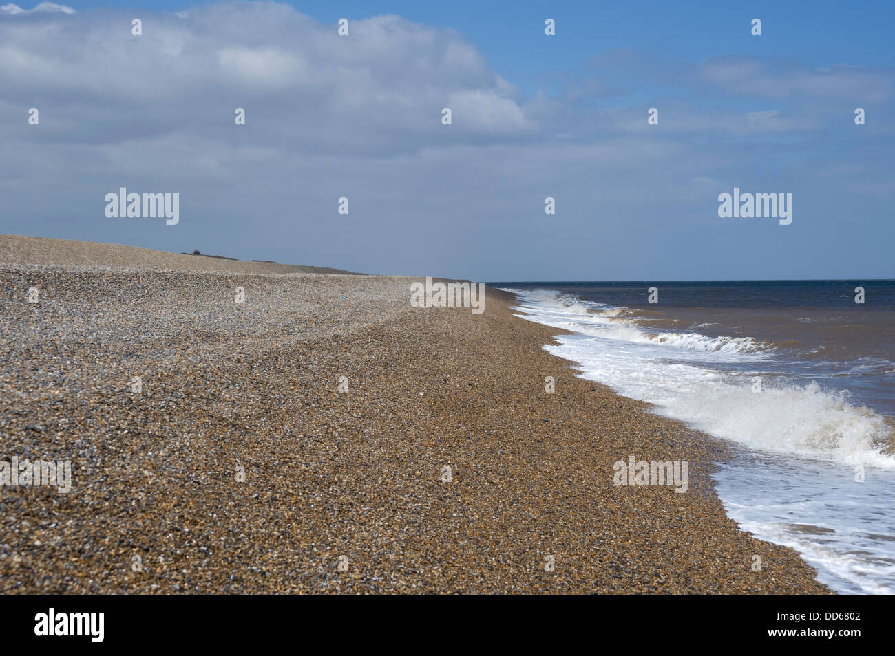 Spiaggia di ciottoli e le difese di mare con onde che lambiscono la spiaggia a Cley-Next-il-Mare, Norfolk, Inghilterra, Regno Unito. Foto Stock