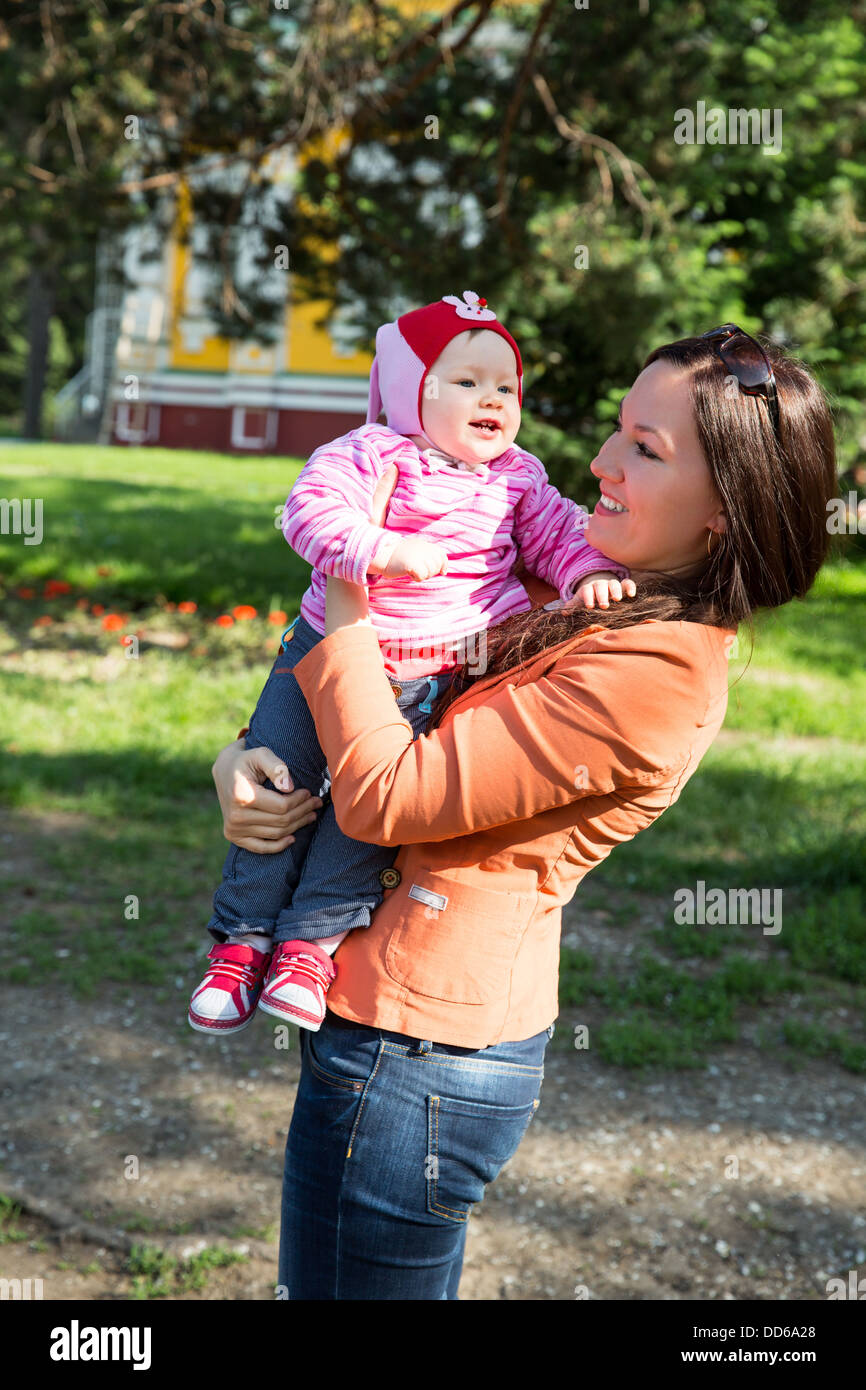 Felice mamma e bambino ragazza avvolgente. Il concetto di infanzia e famiglia. Bella madre e il suo bambino all'aperto Foto Stock