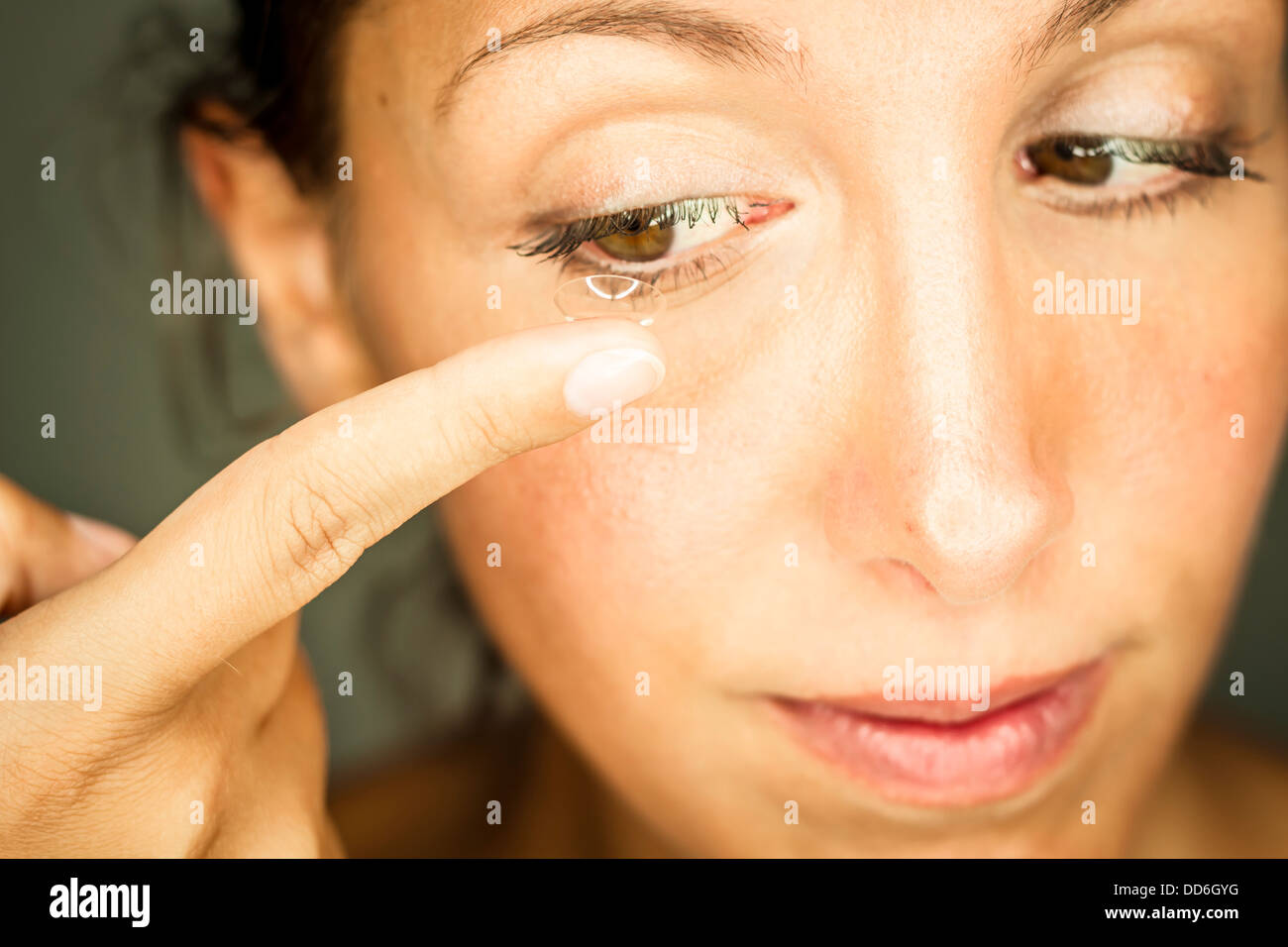 Studio, Frau setzt Kontaktlinse ins Auge ein Foto Stock
