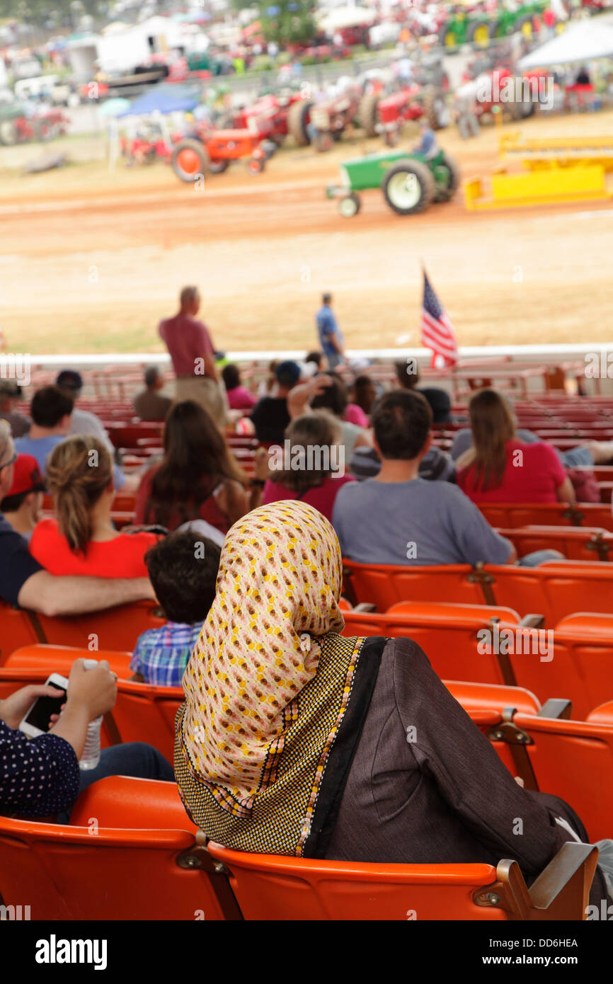 Una donna musulmana osserva un trattore tirando concorso presso la North Carolina State Fairgrounds, Raleigh, North Carolina, STATI UNITI D'AMERICA Foto Stock