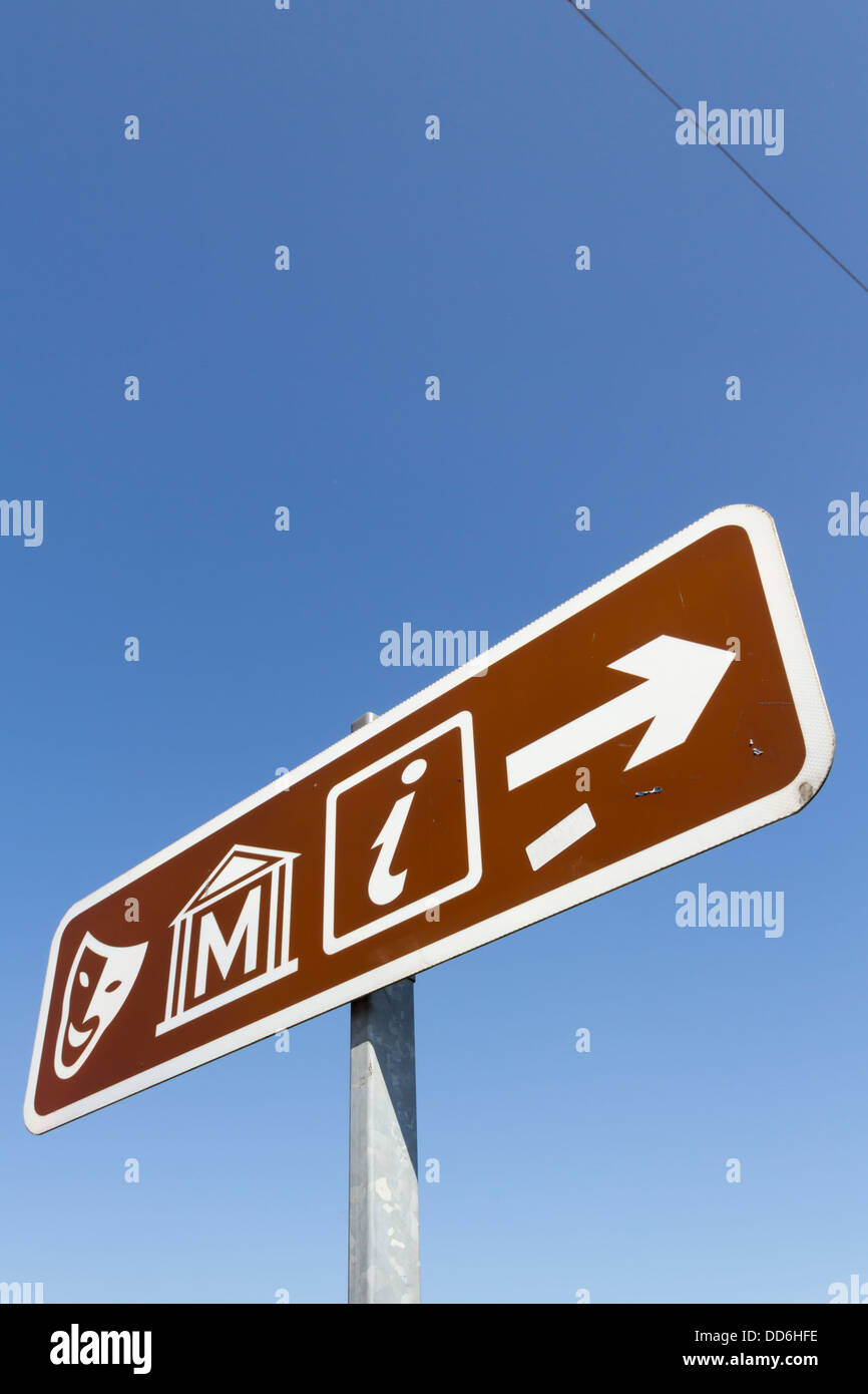 Un Regno Unito marrone Informazioni turistiche signpost in Bolton, compresi i simboli per il teatro/concert hall, museo e informazioni turistiche. Foto Stock