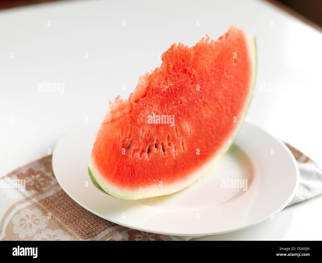 La fetta di rosso di cui è stato eseguito il rip di melone acqua sulla piastra bianca. Foto Stock