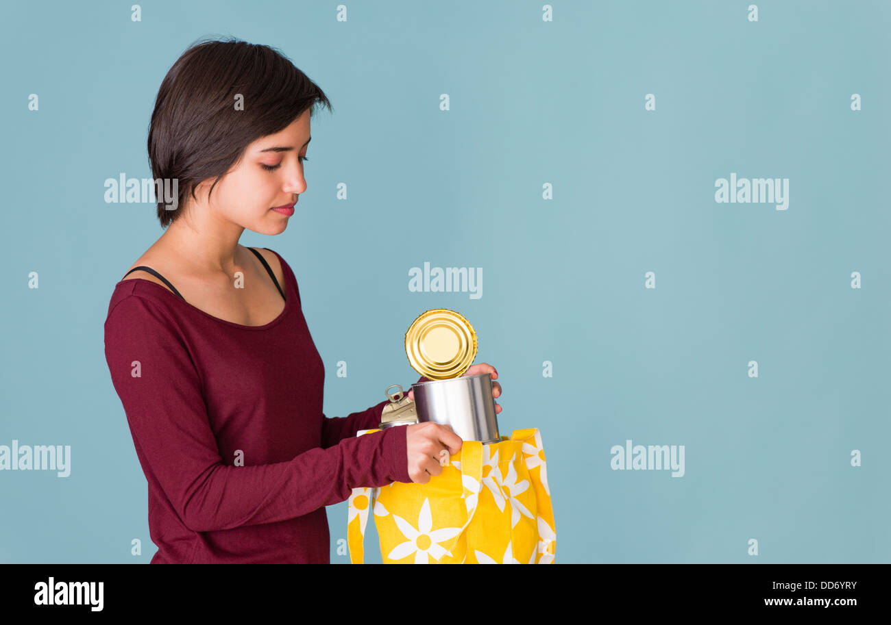 Ritratto di giovane donna multirazziale il riciclaggio di lattine di metallo Foto Stock