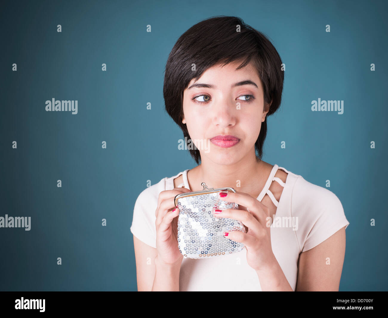 Ritratto di giovane triste multirazziale donna che guarda nel vuoto argento wallet Foto Stock