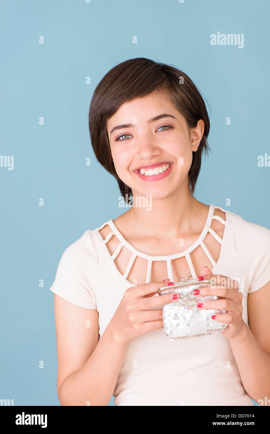 Ritratto di allegro e spensierato e multirazziale giovane donna in possesso di un portafoglio di argento Foto Stock