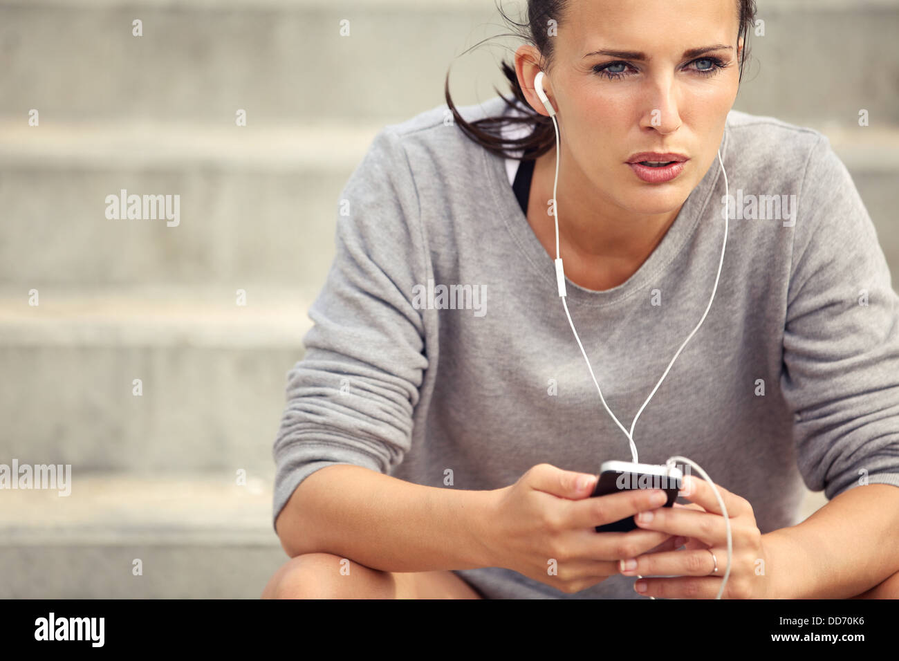 Serio atleta femminile l'ascolto di musica mp3 durante la sua rottura Foto Stock
