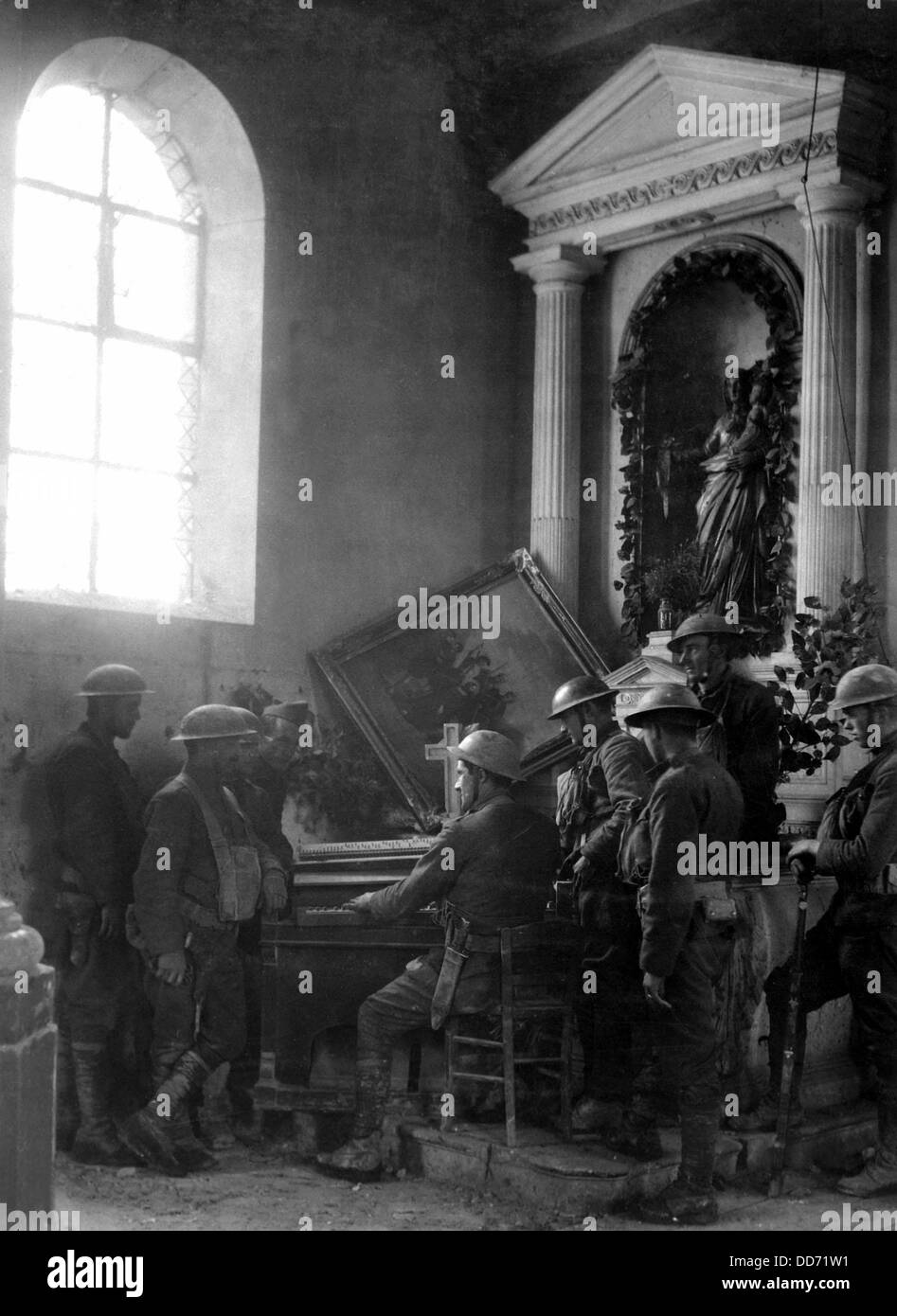 American Guerra mondiale i soldati di ascoltare come uno dei loro compagni riproduce l organo in semi-distrutto vecchia chiesa in Exermont, in Foto Stock
